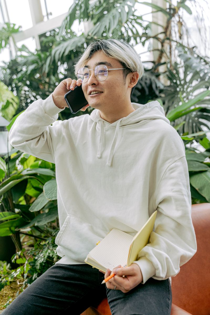 A man on the phone among greenhouse plants