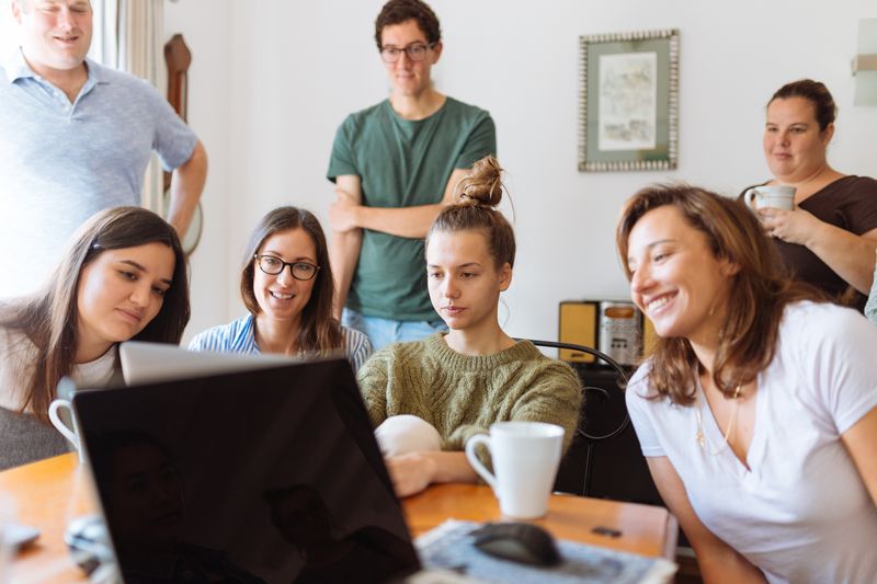 Family and friends gathered around a laptop